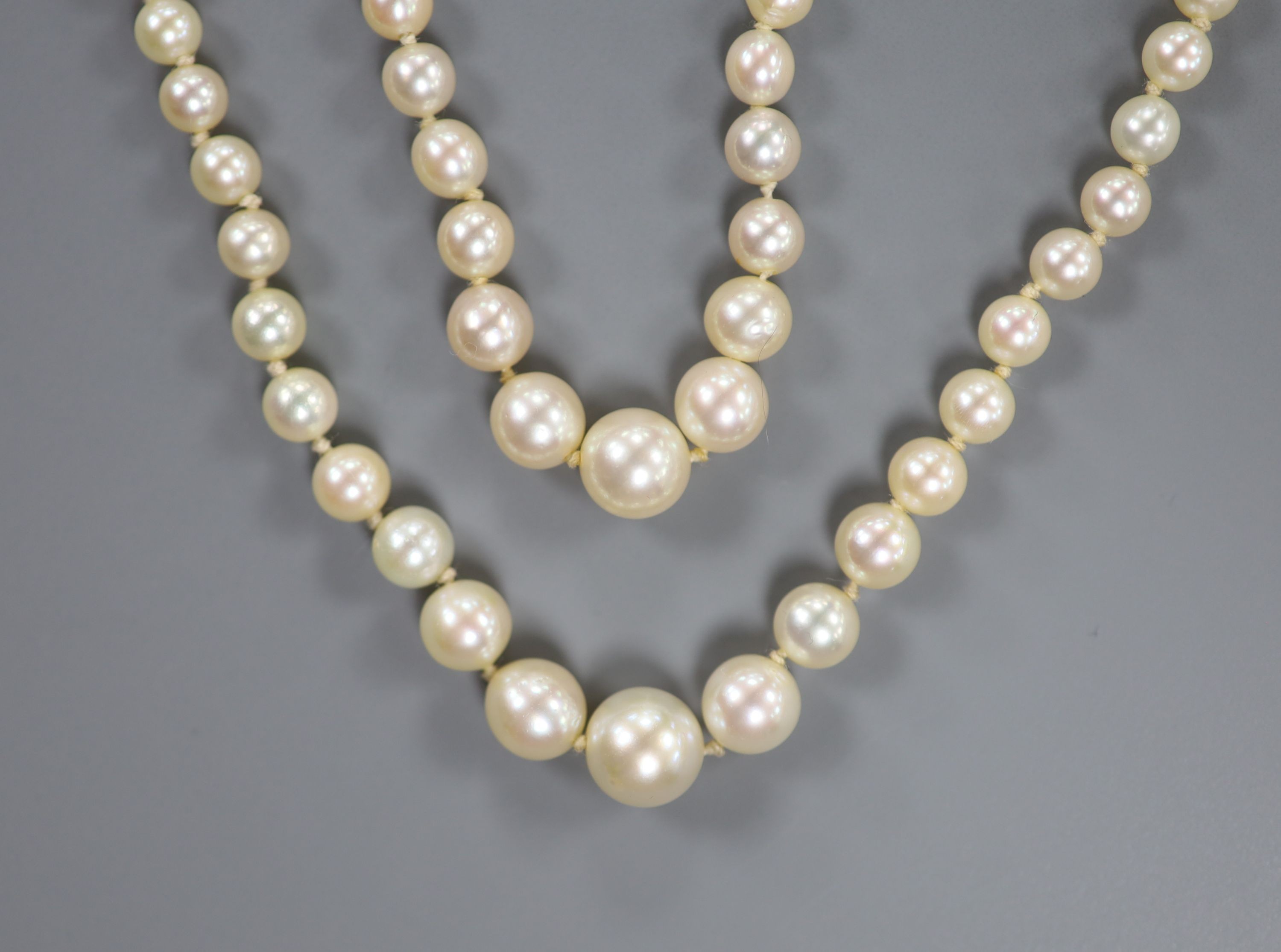 A double strand graduated cultured pearl necklace, with white metal (18ct poincon mark), sapphire and diamond set clasp signed Lacloche Freres and numbered 3763, 46cm, gross weight 33.8 grams